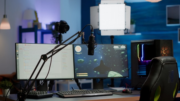 Studio di gioco vuoto con luci a led RGB potente personal computer per lo streaming della competizione online. Display con chat in streaming preparato per torneo virtuale, soggiorno senza nessuno dentro