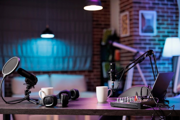 Studio di produzione domestico vuoto con strumenti professionali di podcasting che registrano il suono per i siti di streaming di spettacoli di intrattenimento. Trasmissione in diretta da una posizione accogliente nel soggiorno decorato con luci viola