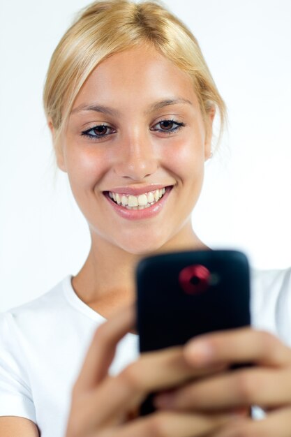 Studio Ritratto di bella giovane donna con cellulare.