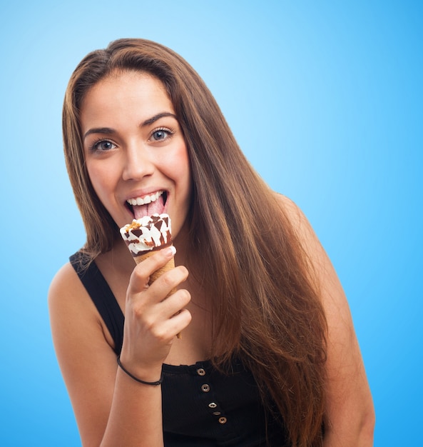 Studio ritratto di donna che lecca il gelato.