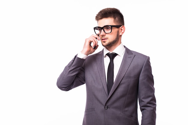 Studio shot di un giovane uomo d'affari con occhiali che parla al cellulare