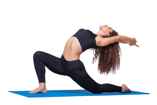 Studio shot di una giovane donna in forma facendo esercizi di yoga.