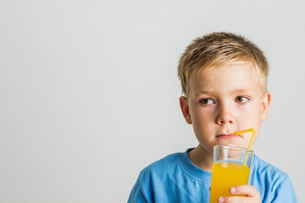 Succo bevente del bambino sveglio del primo piano