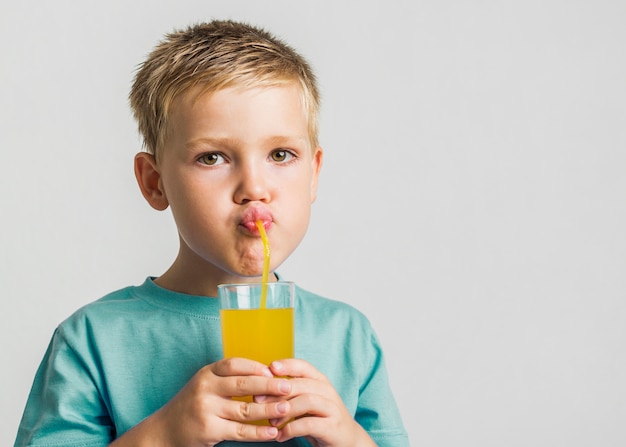 Succo bevente del bambino sveglio del primo piano