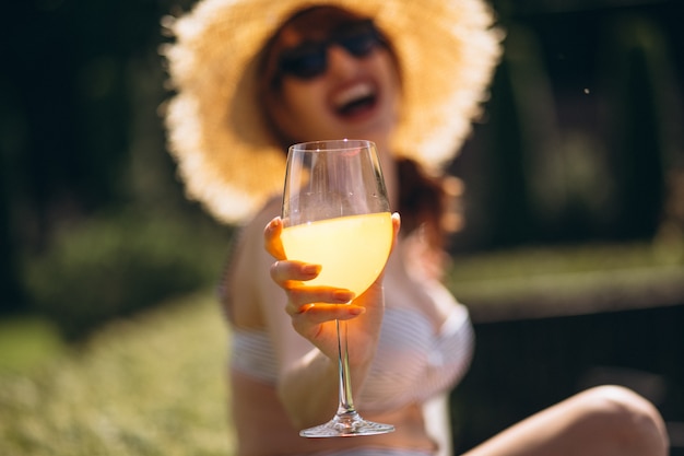 Succo bevente della donna graziosa in costume da bagno