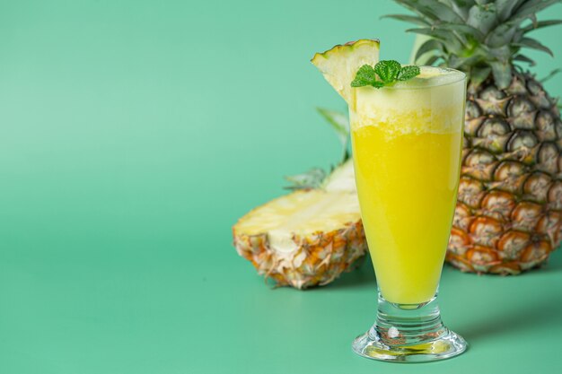 Succo d'ananas sulla superficie verde