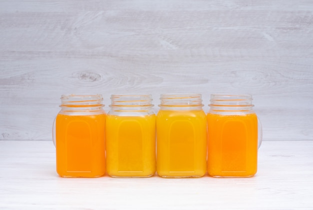 Succo di limone e dell'arancia in vetri sulla tavola bianca