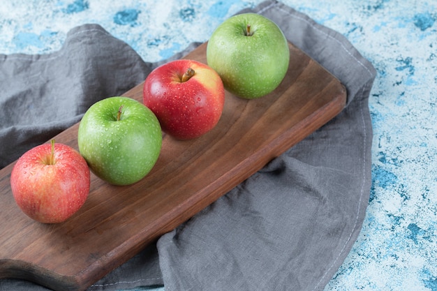 Succose mele isolate su un piatto di legno.
