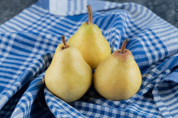 Succose pere gialle su carta da cucina a quadretti blu