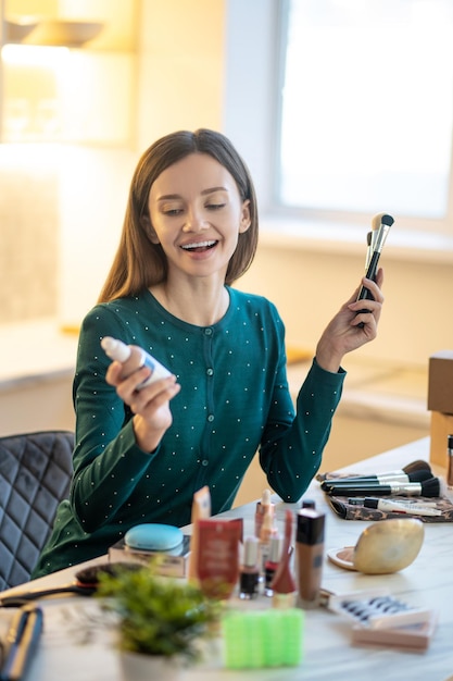 Suggerimenti per il trucco. Giovane cosmetologo sorridente che spiega i segreti del buon trucco