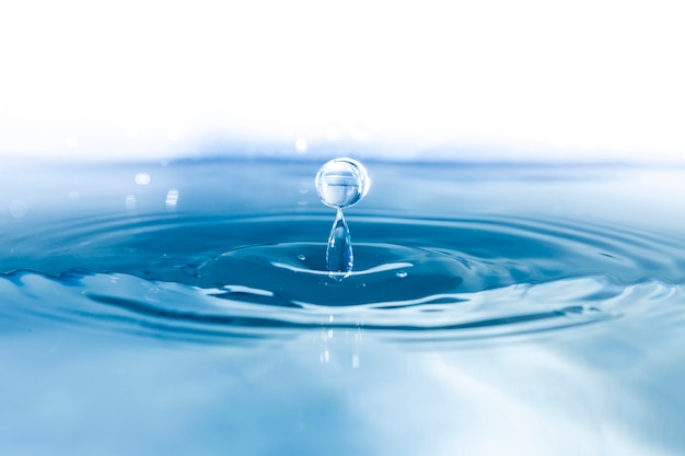 Superficie d'acqua con ondulazioni e gocce che cadono