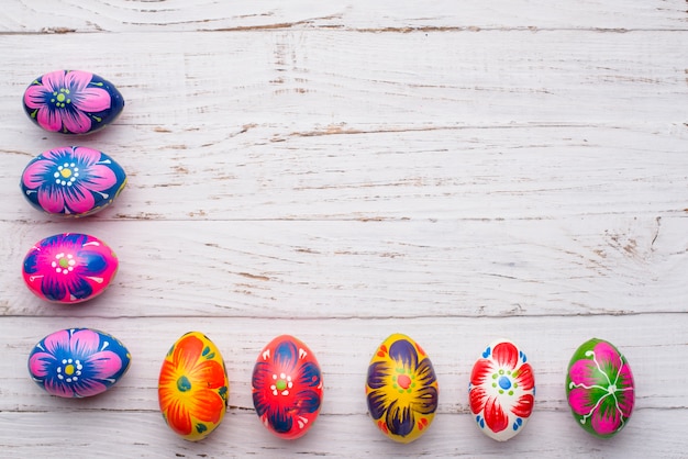 superficie di legno bianco con le uova colorate per pasqua