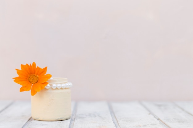 superficie di legno bianco con vaso e fiori d&#39;arancio