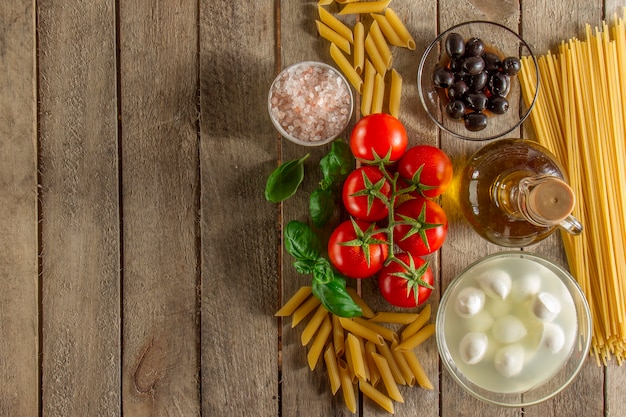 Superficie di legno con gli ingredienti per cottura della pasta