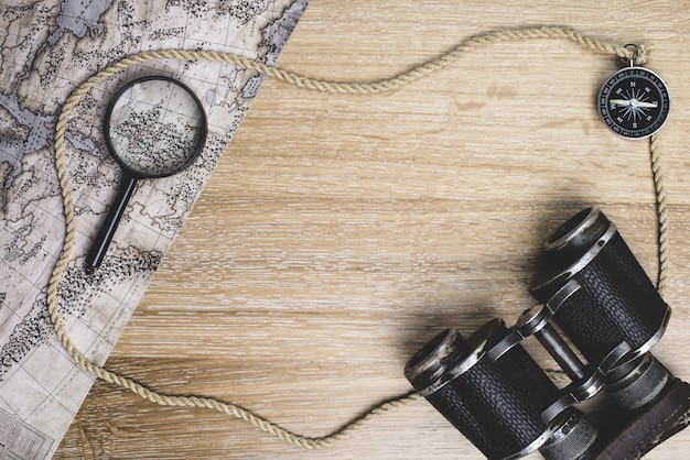 Superficie di legno con la mappa e gli altri elementi di viaggio