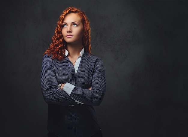 Supervisore femminile rossa vestita con un abito elegante su sfondo grigio.