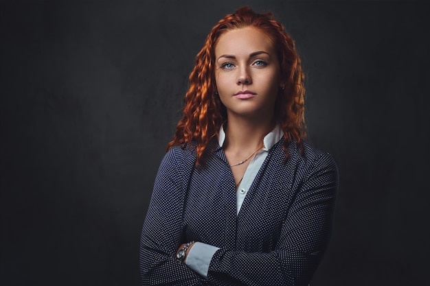 Supervisore femminile rossa vestita con un abito elegante su sfondo grigio.