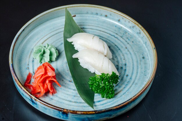 Sushi del sashimi di vista frontale con il pesce bianco con wasabi e lo zenzero su un piatto