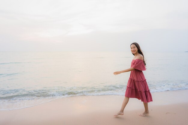 Svago felice di sorriso della bella giovane donna asiatica del ritratto sul mare e sull&#39;oceano della spiaggia