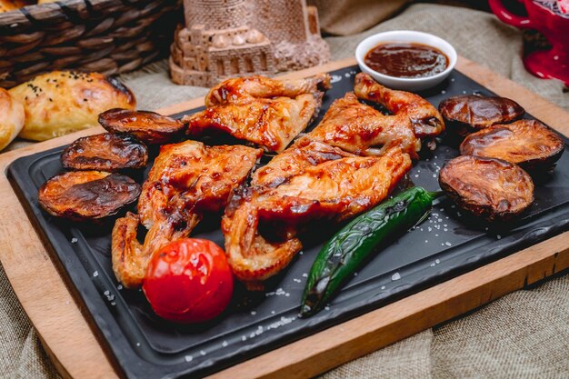 Tabaka del pollo di vista laterale con peperone verde arrostito e salsa caldi della patata al pomodoro su un vassoio