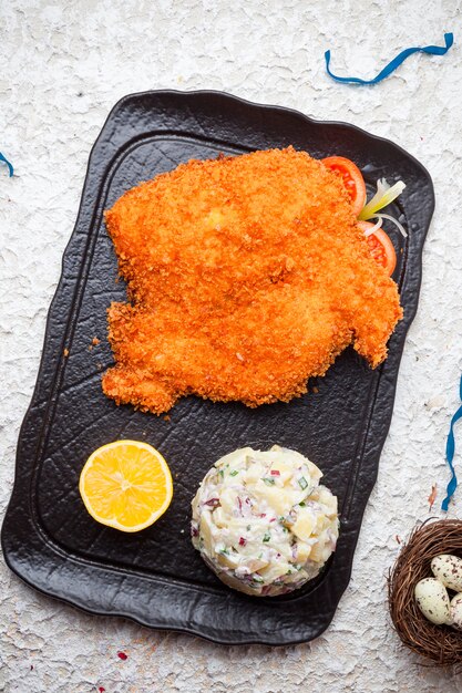 Tabaka vista dall'alto in pastella con insalata di olive e uova di limone e quaglia nel vassoio