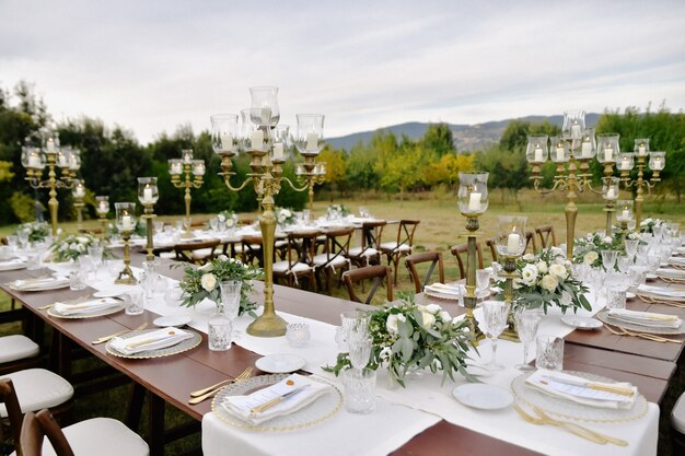 Tabella di celebrazione di cerimonia nuziale decorata con sedili ospiti all'aperto nei giardini con vista sulle montagne