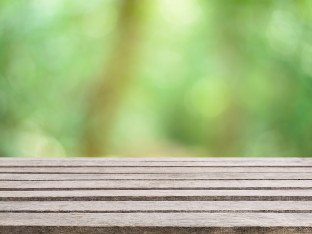 Tabella di legno vuota tabella di fronte a sfondo sfocato. Prospettiva legno marrone su sfocatura alberi in foresta - può essere utilizzato per visualizzare o montare i tuoi prodotti. stagione primaverile. immagine filtrata d&#39;epoca.