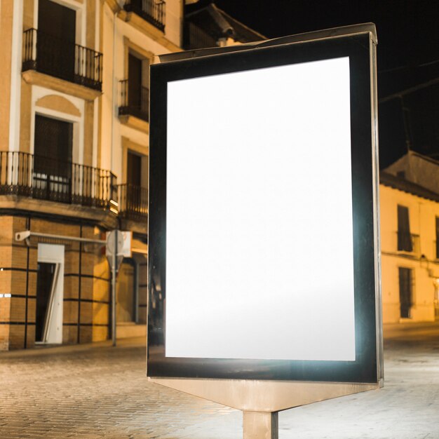 Tabellone per le affissioni verticale illuminato in bianco alla notte