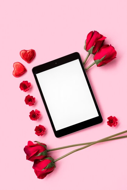 Tablet tra fiori e cuori di ornamento