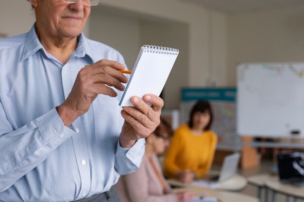 Taccuino senior della tenuta dell'uomo di vista frontale