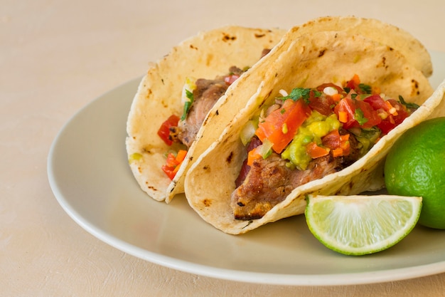 Tacos ad alto angolo e lime sul piatto
