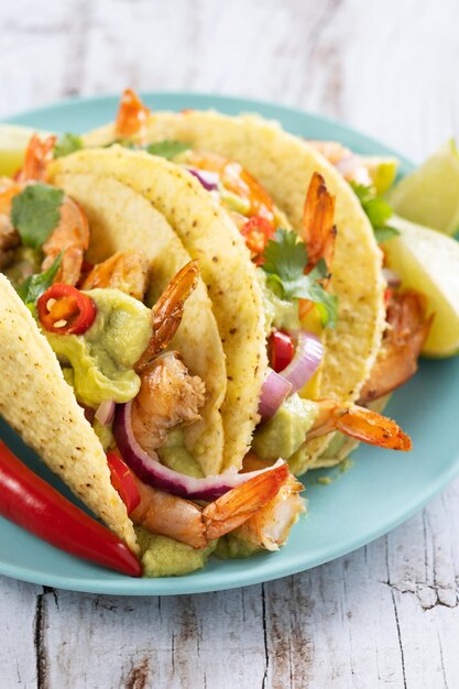 Tacos messicani con gamberettiguacamole e verdure su tavola di legno