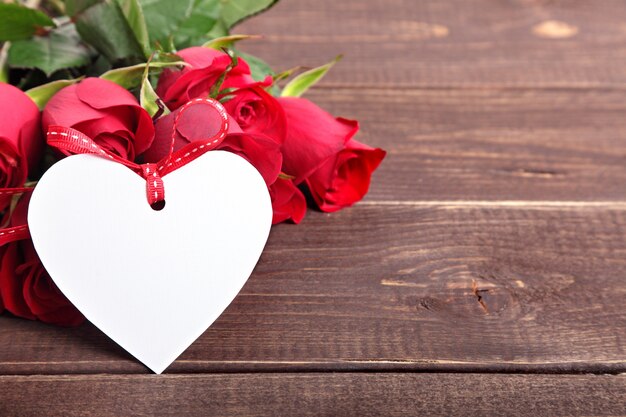 tag cuore di San Valentino e le rose sulla tavola di legno