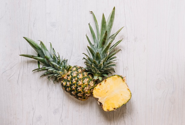 Tagliare l&#39;ananas sul tavolo bianco