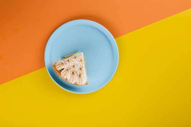 Tagliare la fetta di torta su un piatto blu