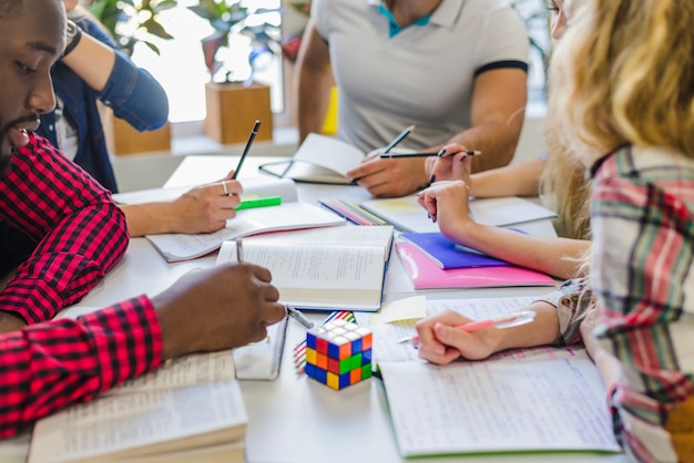 Tagliare le persone con i libri di testo a tavola