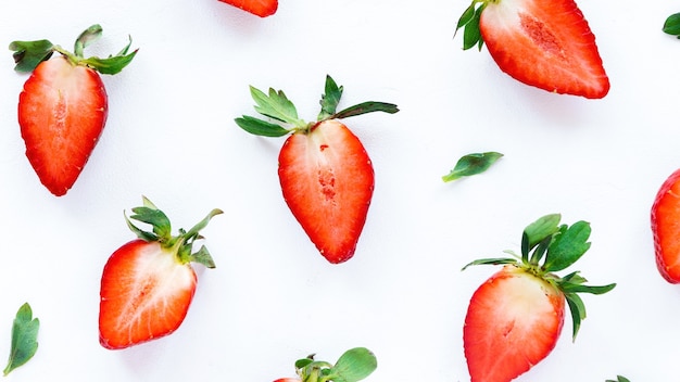 Tagliate a metà le fragole su sfondo bianco