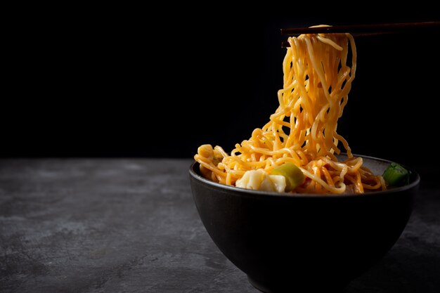 Tagliatella all&#39;uovo con carne di maiale arrosto rossa e wonton sul tavolo.