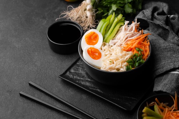 Tagliatelle asiatiche in una ciotola con uova e verdure