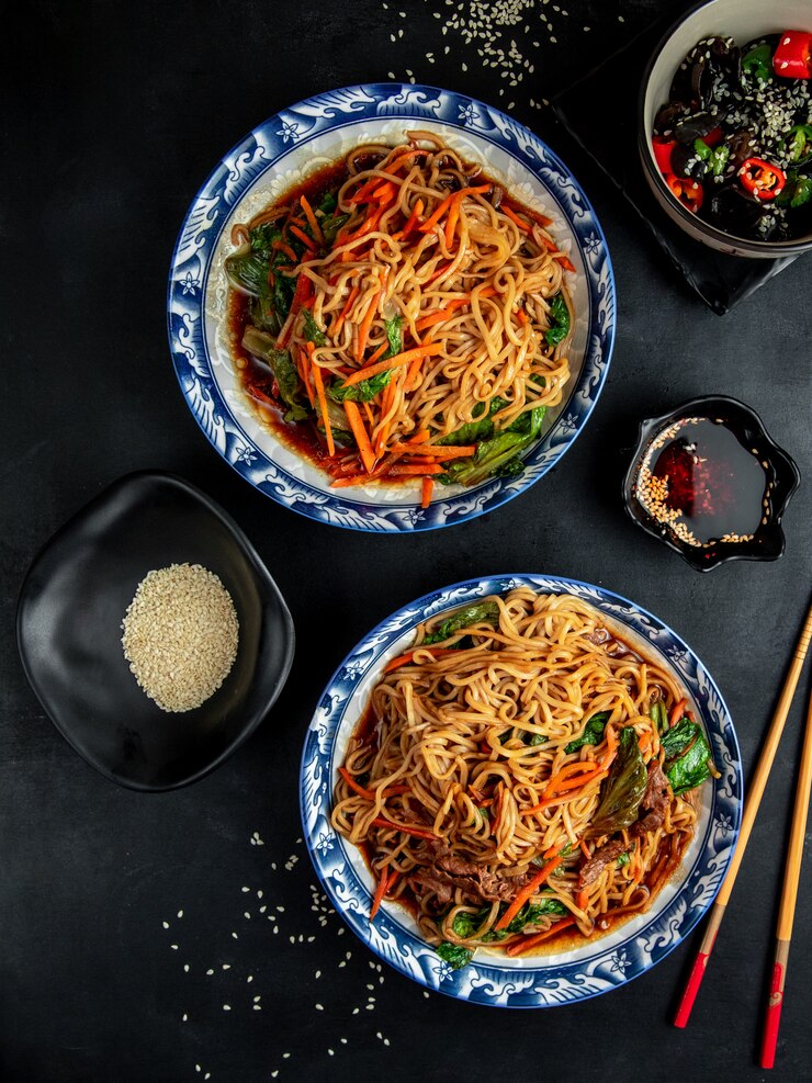 Foto gratuito tagliatelle con carne di manzo e verdure sul tavolo nero