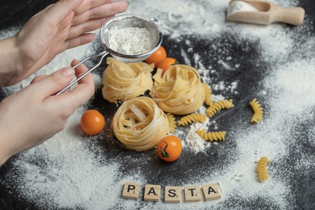 Tagliatelle crude del nido con farina sul nero.