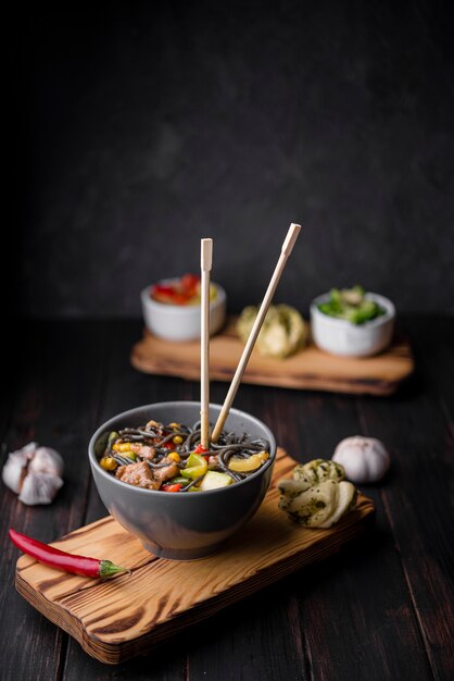 Tagliatelle in ciotola con le bacchette e l'aglio