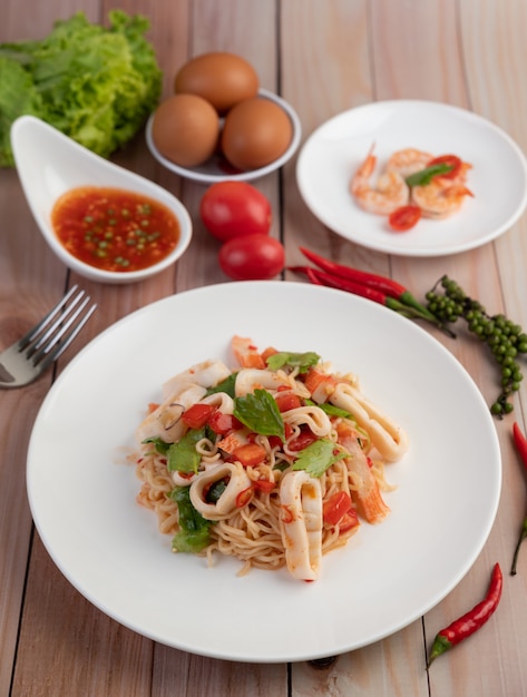 Tagliatelle in padella con inchiostro in un piatto bianco.