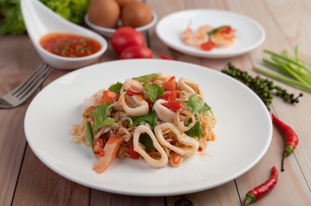 Tagliatelle in padella con inchiostro in un piatto bianco.