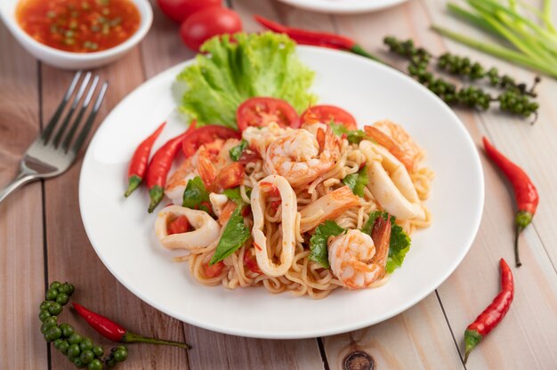 Tagliatelle in padella con inchiostro in un piatto bianco.