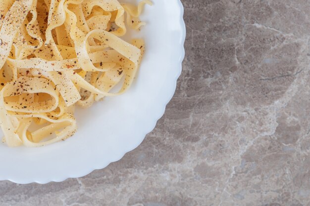 Tagliatelle piccanti appena cotte, sul marmo.