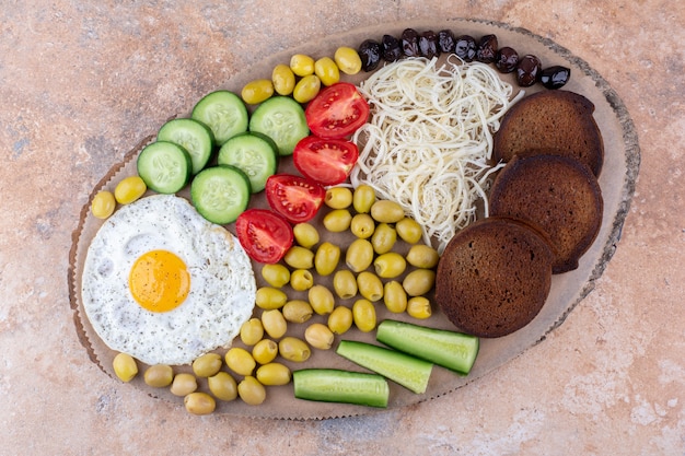 Tagliere colazione con uova fritte e insalata di verdure