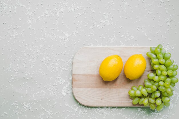 Tagliere con grappolo d&#39;uva e limoni