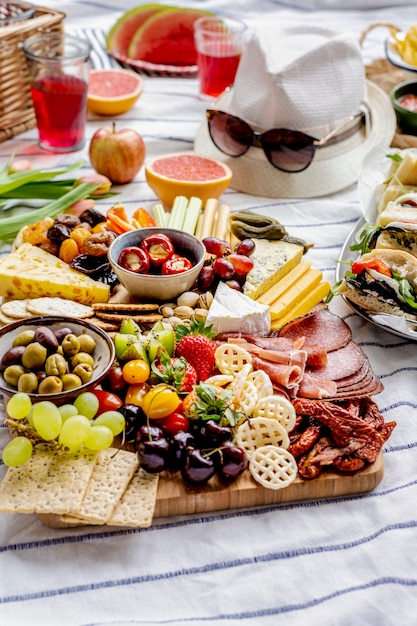 Tagliere di salumi con affettati, frutta fresca e formaggi, picnic estivo