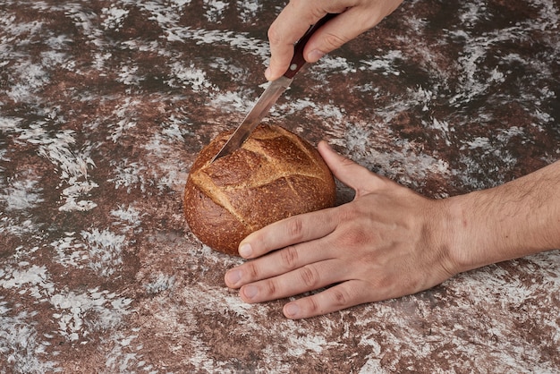 Taglio del pane sullo sfondo di marmo